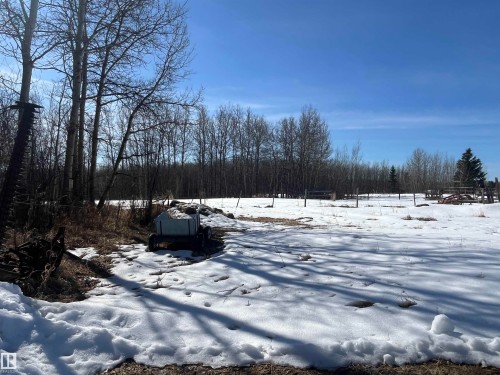 The property features open land with areas of snow cover and a surrounding treeline - 55131 Range Road 83, Rural Yellowhead, AB - Outdoor With View