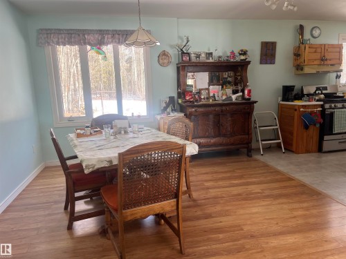 Dining area with hardwood style flooring, a large window providing natural light, and an overhead light fixture - 55131 Range Road 83, Rural Yellowhead, AB - Indoor Photo Showing Dining Room