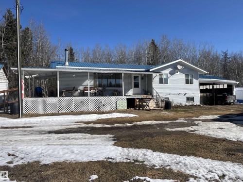 The property features light-colored siding and a blue roof - 55131 Range Road 83, Rural Yellowhead, AB - Outdoor