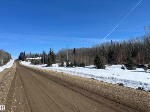 The property features a natural, wooded setting with a gravel road - 55131 Range Road 83, Rural Yellowhead, AB - Outdoor With View