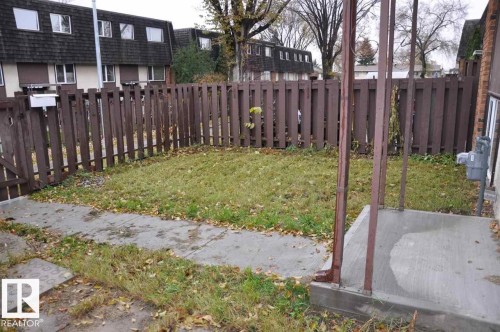 The property features a fenced yard with a lawn and a concrete walkway - 3323 107 Avenue Nw, Edmonton, AB - Outdoor