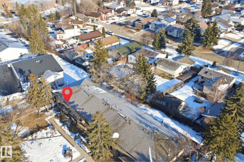 Aerial view of the property with a red locator pin, featuring a large building with a dark roof and surrounding trees - 1706 37 Street, Edmonton, AB - Outdoor With View