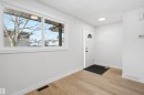 Entryway featuring light wood-style flooring, a large window, a white front door with an arched glass insert, and white walls - 1706 37 Street, Edmonton, AB  - Indoor Photo Showing Other Room 