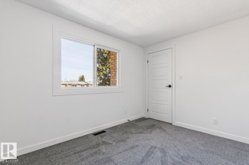 This bright room features a window providing natural light, a white paneled door, and gray carpeting - 95 Ridgewood Terrace, St. Albert, AB - Indoor Photo Showing Other Room