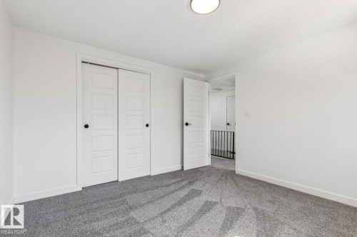 This room features light grey carpet, white walls, and a modern ceiling light fixture - 95 Ridgewood Terrace, St. Albert, AB - Indoor Photo Showing Other Room