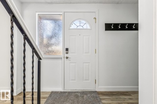 The property features a white front door with an arched window, complemented by a side light window, and light wood-style flooring - 95 Ridgewood Terrace, St. Albert, AB - Indoor Photo Showing Other Room