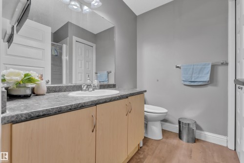 Bathroom featuring a light wood vanity with a dark countertop, a white sink, and light gray walls - 3609 11 Street, Edmonton, AB - Indoor Photo Showing Bathroom