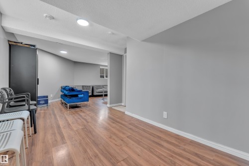 The property features wood-style flooring and light grey walls - 3609 11 Street, Edmonton, AB - Indoor Photo Showing Other Room