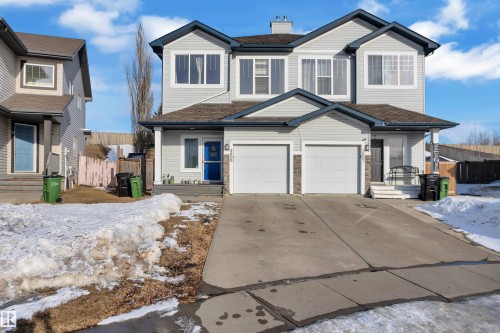 The property features a two-story exterior with light-colored siding, a dark roof, and white-framed windows - 3609 11 Street, Edmonton, AB - Outdoor With Facade