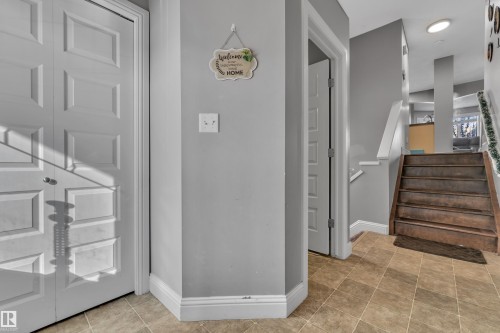 The property features a entryway with light-colored tile flooring and a staircase with wooden treads and a white handrail - 3609 11 Street, Edmonton, AB - Indoor Photo Showing Other Room