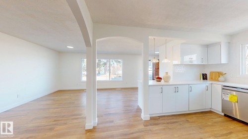 The property features an open-concept living space with light wood-style flooring throughout - 8515 86 Avenue, Edmonton, AB 