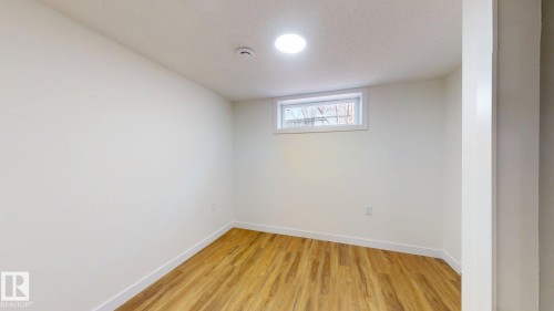 This room features light wood-style flooring and a window providing natural light - 8515 86 Avenue, Edmonton, AB 