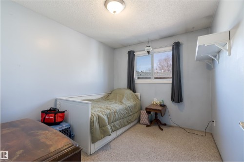This room features neutral wall paint, a window with curtains, and carpeting - 28 Camelot Avenue, Leduc, AB - Indoor Photo Showing Bedroom