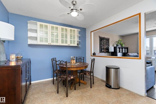 This dining area features tile flooring, a ceiling fan with integrated lighting, and a partial wall opening to an additional living space - 28 Camelot Avenue, Leduc, AB - Indoor