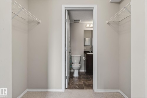 The property features a closet with wire shelving and a neutral color palette - 215 1080 Mcconachie Boulevard, Edmonton, AB - Indoor