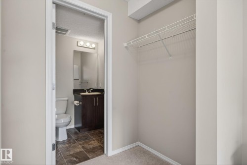 This space features a built-in wire shelf, providing convenient storage - 215 1080 Mcconachie Boulevard, Edmonton, AB - Indoor Photo Showing Bathroom