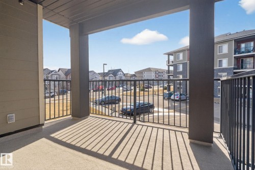 The property features an exterior balcony with a concrete floor and black metal railings, offering an outdoor living space - 215 1080 Mcconachie Boulevard, Edmonton, AB - Outdoor With Balcony With Exterior