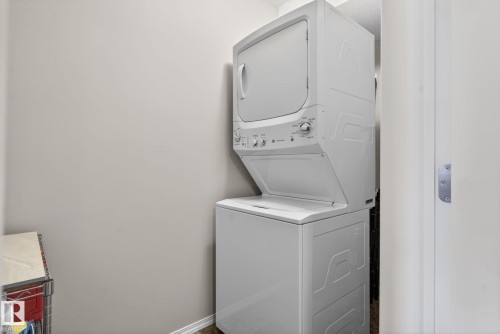 Dedicated laundry space featuring a white stackable washer and dryer unit - 215 1080 Mcconachie Boulevard, Edmonton, AB - Indoor Photo Showing Laundry Room