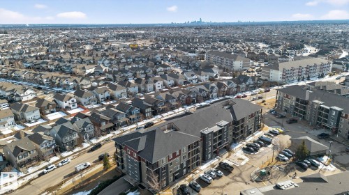 This aerial view highlights the property's location within a developed community, featuring a mix of multi-story buildings and residential homes - 215 1080 Mcconachie Boulevard, Edmonton, AB - Outdoor With View