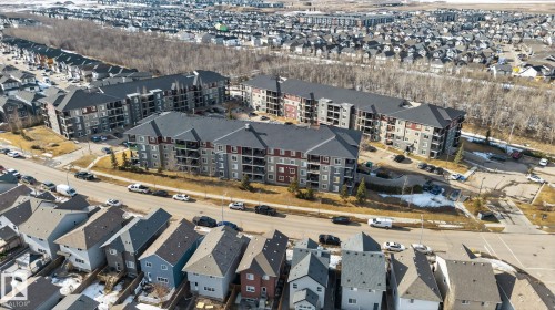 Aerial view showcasing the property's location within a developed community featuring various residential buildings, including multi-story structures with balconies, and detached homes - 215 1080 Mcconachie Boulevard, Edmonton, AB - Outdoor With View