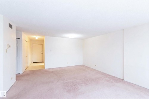 Spacious interior room featuring light-colored carpeting, white walls, and overhead lighting - 1004 11027 87 Avenue, Edmonton, AB - Indoor Photo Showing Other Room