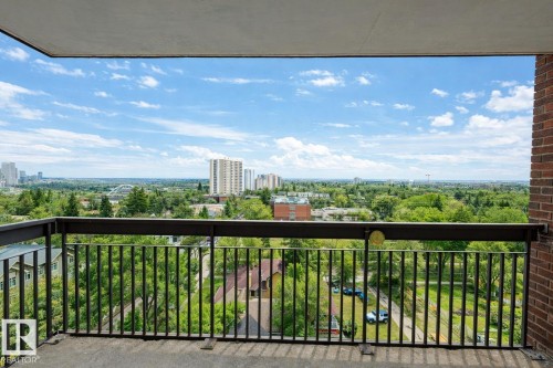 This property features a balcony with a metal railing and a concrete floor, offering expansive views of the cityscape and lush green areas - 1004 11027 87 Avenue, Edmonton, AB - Outdoor With Balcony With View