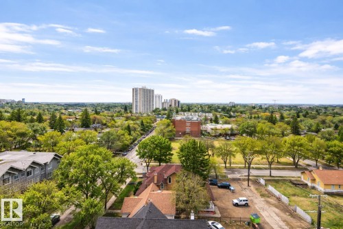 Expansive aerial view showcasing the surrounding area with a mix of residential properties, mature trees, and high-rise buildings in the distance - 1004 11027 87 Avenue, Edmonton, AB - Outdoor With View