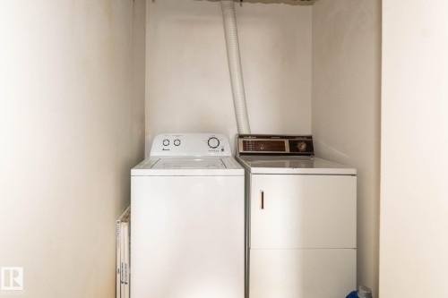 Dedicated laundry area featuring a white top-loading washing machine and a white dryer - 1004 11027 87 Avenue, Edmonton, AB - Indoor Photo Showing Laundry Room