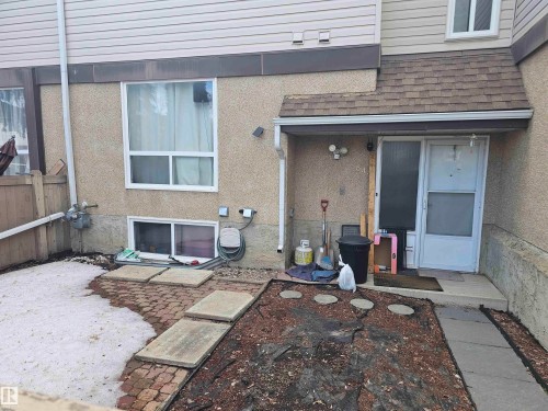 The property features a stucco exterior with vinyl siding and a shingled roof over the entrance - 844 Erin Place, Edmonton, AB - Outdoor With Exterior
