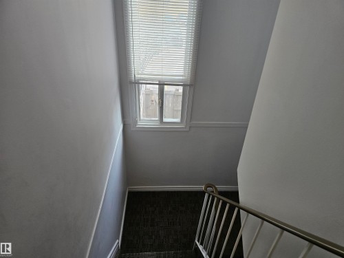 Stairwell featuring white walls, a window with blinds, and a metal handrail - 844 Erin Place, Edmonton, AB - Indoor Photo Showing Other Room