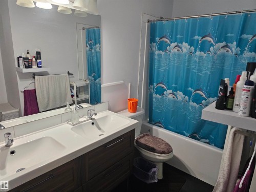 Well-appointed bathroom featuring a double vanity with two sinks, a wall-mounted mirror, and a shower-tub combination - 844 Erin Place, Edmonton, AB - Indoor Photo Showing Bathroom