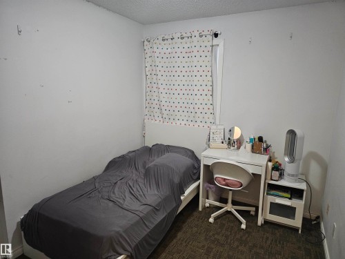 This room features a window with a patterned curtain, a bed frame, and carpeted flooring - 844 Erin Place, Edmonton, AB - Indoor Photo Showing Bedroom