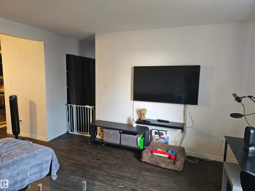 The property features dark wood-style flooring throughout the visible area - 844 Erin Place, Edmonton, AB - Indoor Photo Showing Bedroom