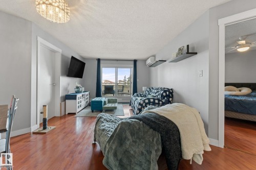 Living area featuring hardwood flooring, a decorative chandelier, and access to an outdoor balcony - 208 6710 158 Avenue, Edmonton, AB - Indoor Photo Showing Living Room