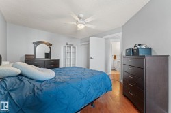 Bedroom featuring hardwood floors, a white ceiling fan, and light grey walls - 