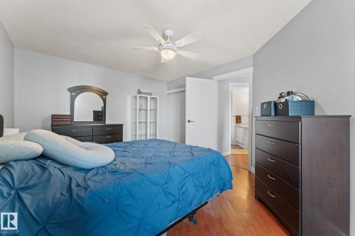 Bedroom featuring hardwood floors, a white ceiling fan, and light grey walls - 208 6710 158 Avenue, Edmonton, AB - Indoor Photo Showing Bedroom