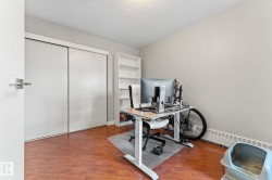 Room featuring warm wood flooring, neutral tone walls, and white bi-fold closet doors - 