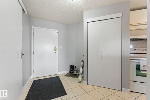 Entryway featuring tile flooring, a white entry door, and a closet with sliding doors - 208 6710 158 Avenue, Edmonton, AB - Indoor Photo Showing Other Room
