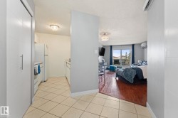 The property features a kitchen with tiled floors and white appliances - 