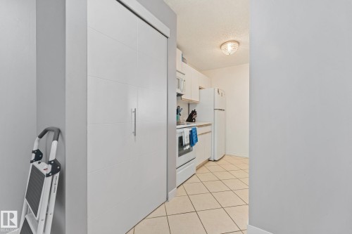 The kitchen features white cabinetry, a white refrigerator, and a white oven - 208 6710 158 Avenue, Edmonton, AB - Indoor