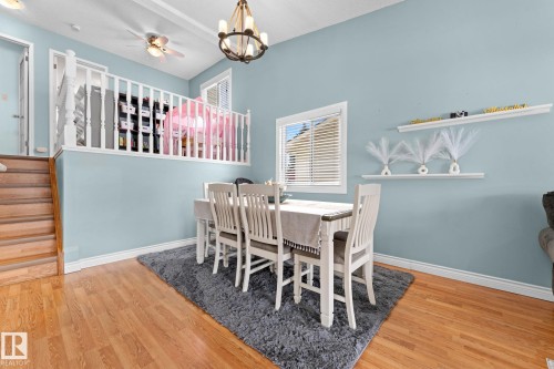 Dining area featuring hardwood floors, a chandelier, and a window with blinds - 7252 152C Avenue, Edmonton, AB - Indoor Photo Showing Dining Room