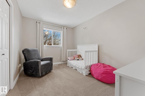 This room features light neutral-toned walls, a window with curtains, and carpeting - 7252 152C Avenue, Edmonton, AB - Indoor Photo Showing Bedroom