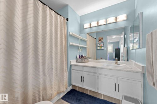 Bathroom featuring a vanity with a single sink, white cabinetry, and a large mirror - 7252 152C Avenue, Edmonton, AB - Indoor Photo Showing Bathroom