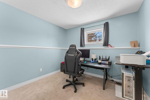 This room features light blue walls, a window with dark curtains, and carpeted flooring - 7252 152C Avenue, Edmonton, AB - Indoor Photo Showing Office