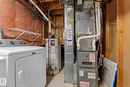 Laundry area featuring a clothes dryer, water heater, and furnace - 7252 152C Avenue, Edmonton, AB - Indoor Photo Showing Basement