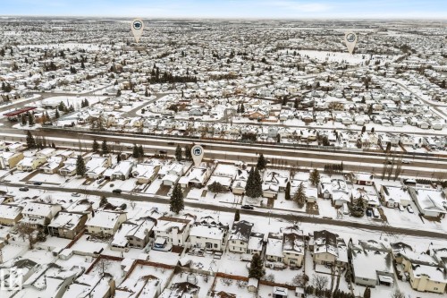 Aerial view of the neighborhood showing residential properties with snow-covered roofs and yards, a road, and trees - 7252 152C Avenue, Edmonton, AB - Outdoor With View