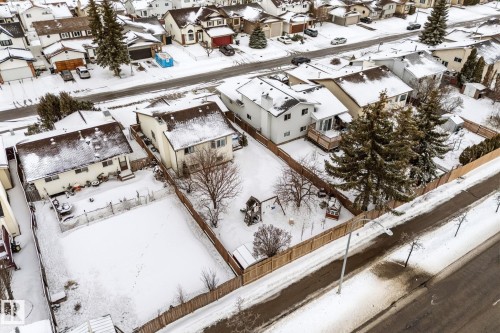 This aerial view showcases the property's large backyard, complete with mature trees and a wooden fence - 7252 152C Avenue, Edmonton, AB - Outdoor With View