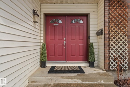 The property features a double front entry door with decorative glass inserts, complemented by concrete steps leading to the entrance - 7252 152C Avenue, Edmonton, AB - Outdoor With Exterior