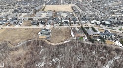 Aerial view showcasing a residential area with a mix of established homes and undeveloped land parcels - 