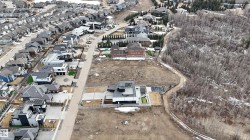 This property offers a unique setting with a residential street, a wooded area, and a large open lot - 